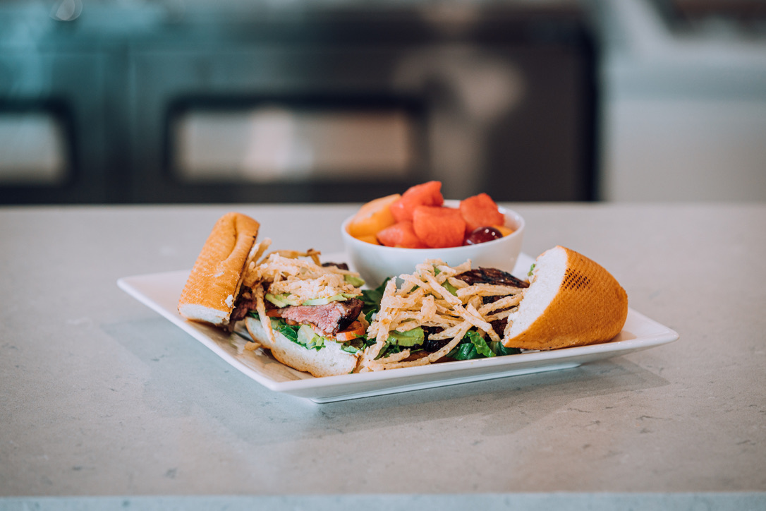 steak sandwich with a side of fruit